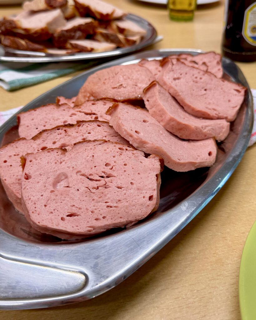 Frisch aufgeschnittener Leberkäs auf einer Servierplatte.